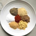 Plate with seven separate seasonings labeled to be blended into this Brazilian Steak Seasoning.