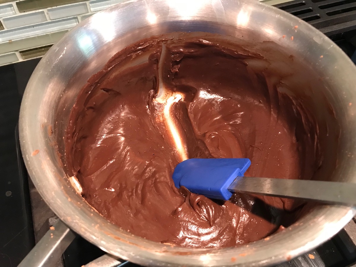 Evaporated milk and chocolate combined and thick in a pan being separated with a spatula. This Brigadeiro Recipe is based on traditional Brazilian chocolate dessert truffles rolled in sprinkles. You won't believe how easy they are to make!