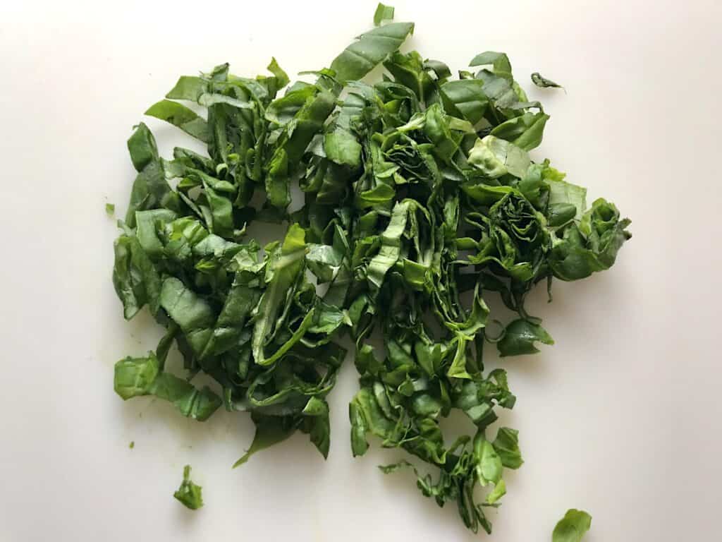 Sliced basil leaves for Tomato and Onion Salad.