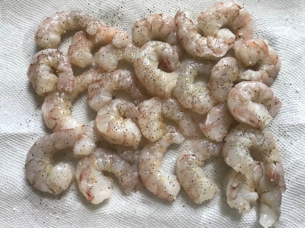 Seasoned raw shrimp on paper towel for Coconut Shrimp Stew Recipe.