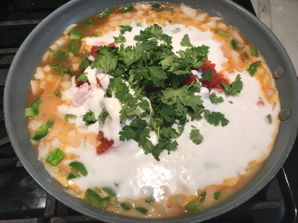 Coconut milk, broth, and cilantro added to skillet for Coconut Shrimp Stew Recipe.