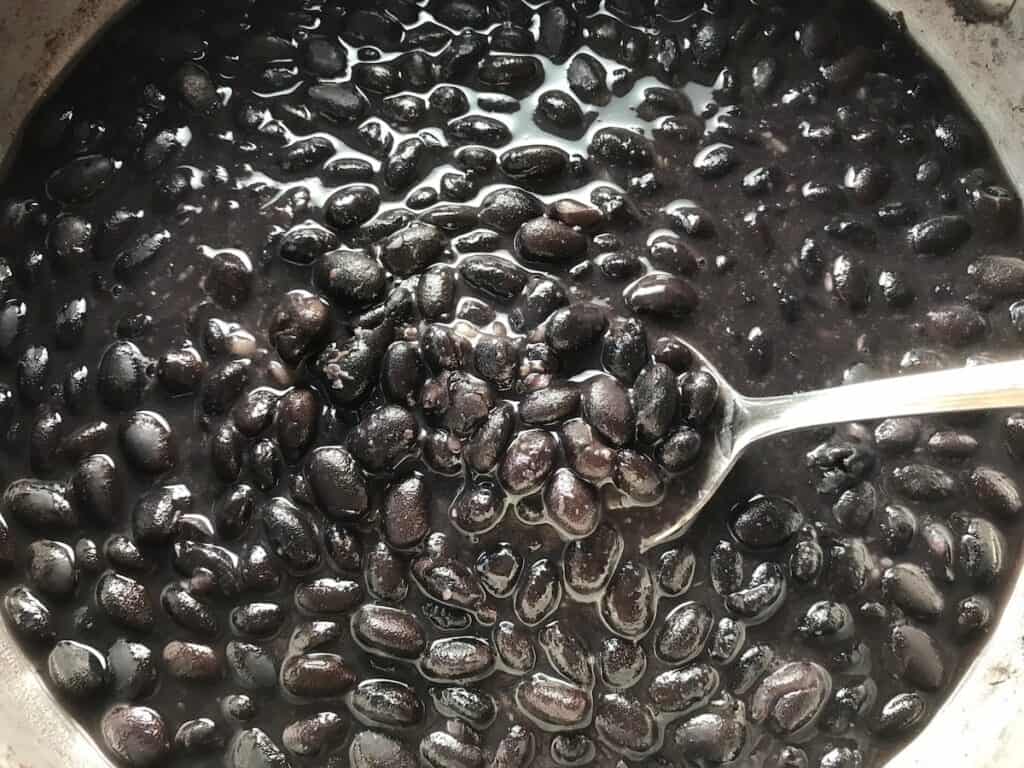 Cooked black beans in a pot for Brazilian Black Bean Puree, or Tutu de Feijão.