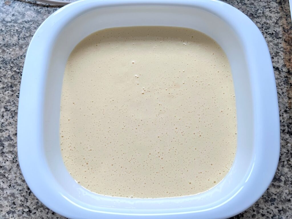 Cake batter in square baking dish before baking for Brazilian Coconut Cake.