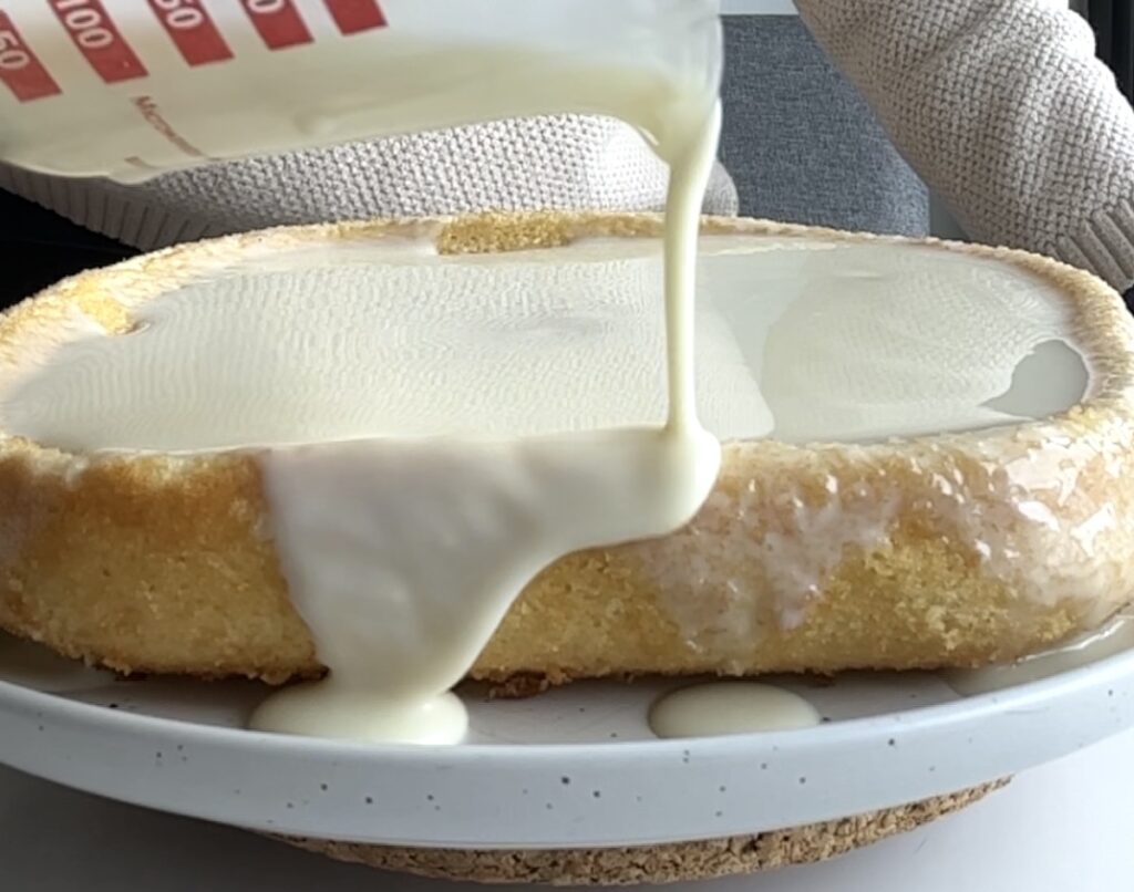 Pouring glaze over Brazilian Coconut Cake.