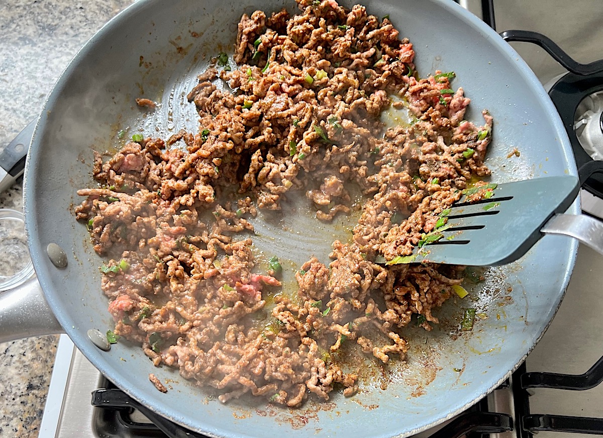 Ground beef filling cooked in a skillet for Brazilian Pastel recipe.