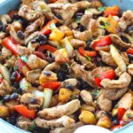 Brazilian Marinated Chicken Stir Fry with pineapple, black beans, red Pepper and onions in a skillet wrapped in a towel with cilantro garnish. It is truly one amazing dish with incredible flavor!