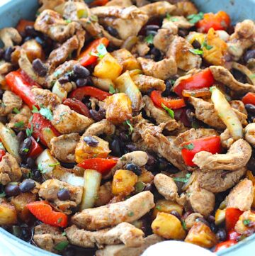 Brazilian Marinated Chicken Stir Fry with pineapple, black beans, red Pepper and onions in a skillet wrapped in a towel with cilantro garnish. It is truly one amazing dish with incredible flavor!