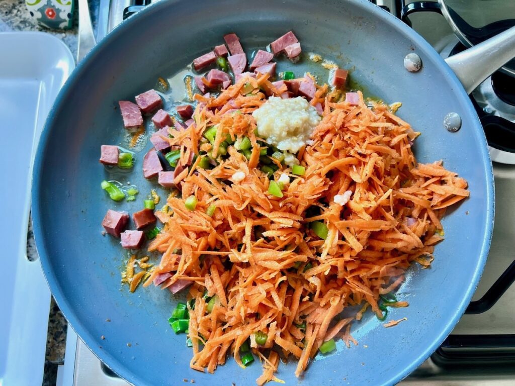 Carrots, garlic, sausage, and scallions added to pan for Brazilian Farofa Recipe.