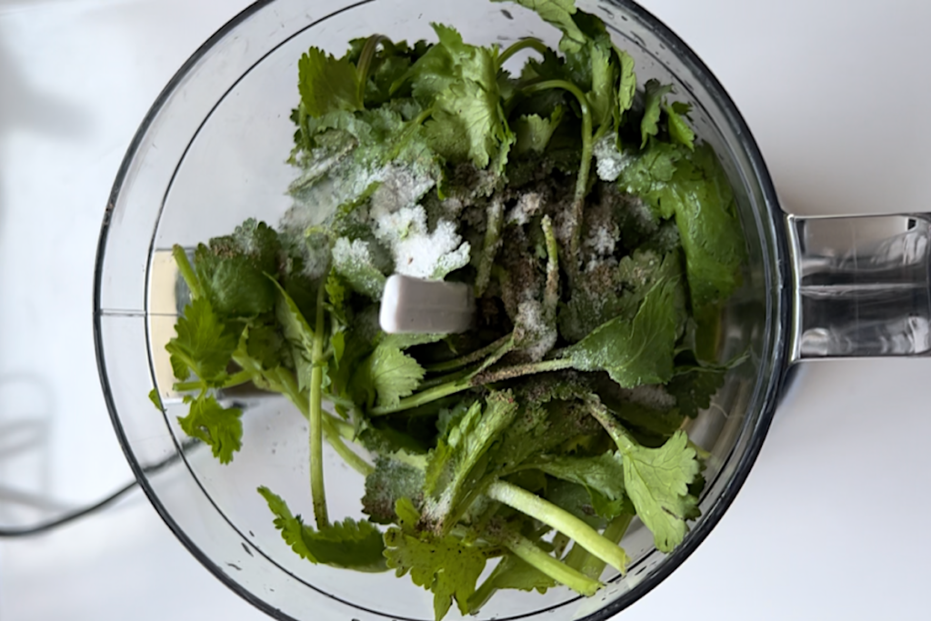 Fresh cilantro and other ingredients in food processor for Brazilian Cilantro Chimichurri recipe.
