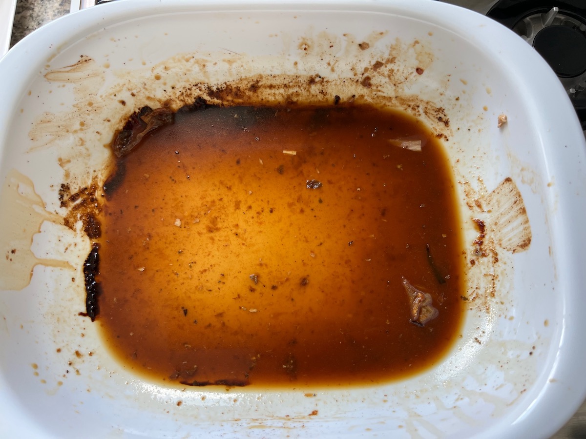 Roasting pan with pork ribeye roast drippings mixed with water and scraped up from the bottom of the pan.