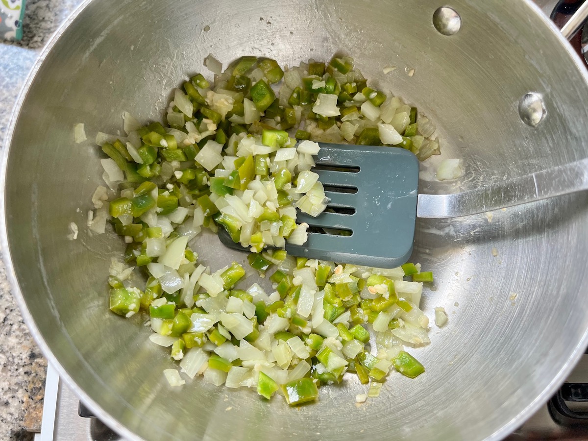 Green pepper, onion, and garlic cooked in a pot for the Ultimate chicken casserole recipe.