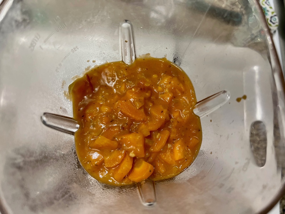 Chunky carrot sauce in a blender before blending smooth.