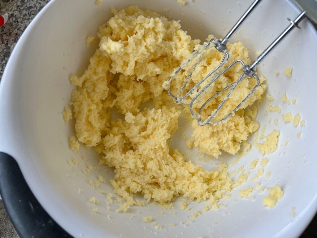 Hand mixer whipping the butter and sugar together in a large bowl for Brigadeiro Brazilian Cake.