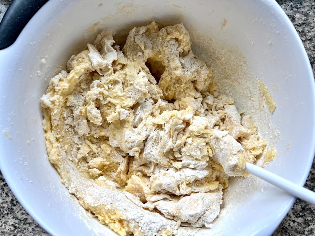 Spoon mixing flour into cake batter for Brigadeiro Brazilian Cake.