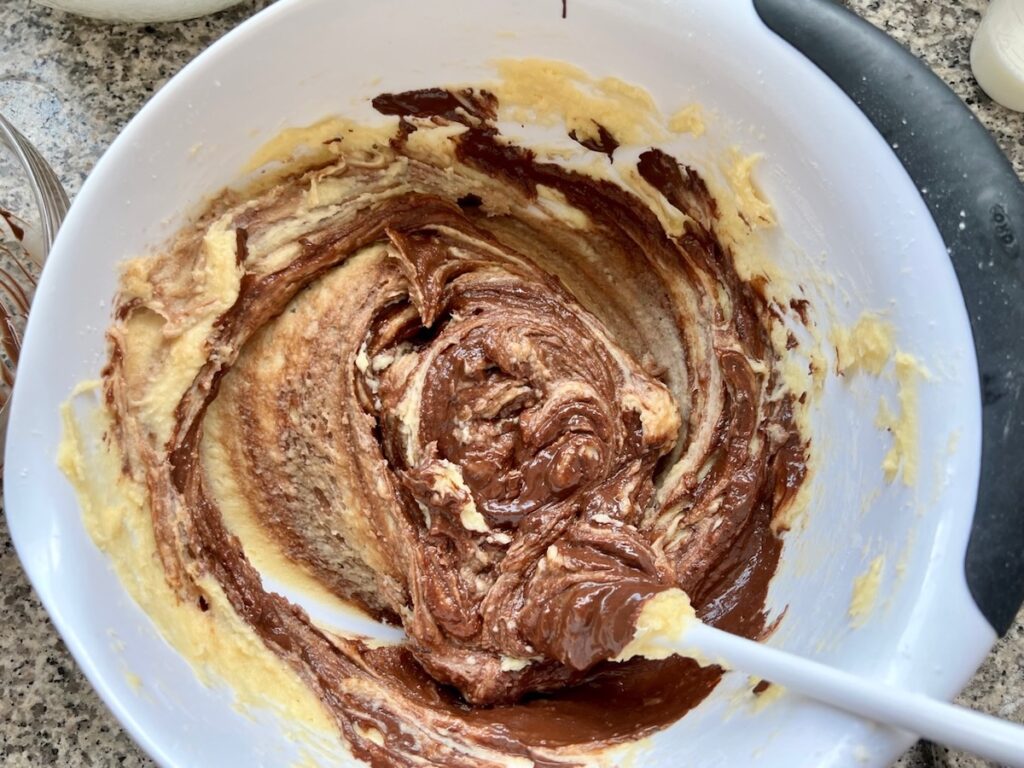 Melted chocolate being mixed into the cake batter for Brigadeiro Brazilian Cake.