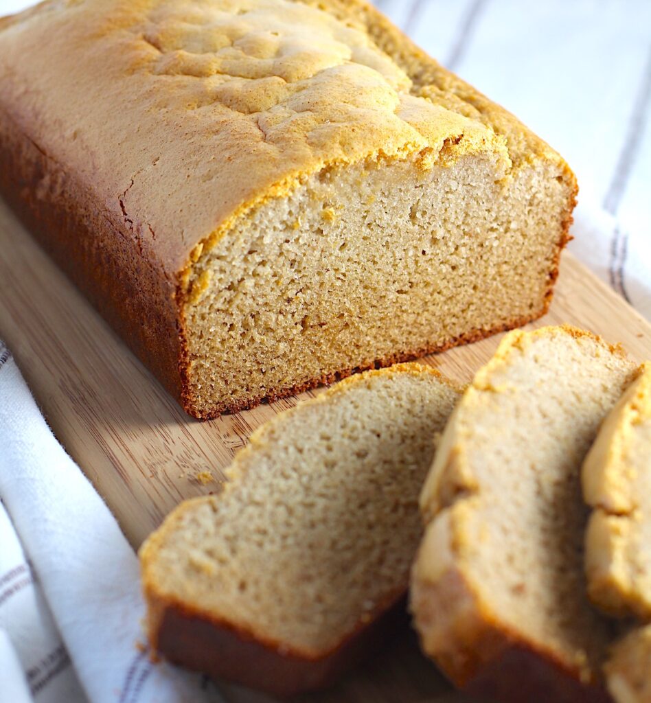 Cassava Bread loaf on a wood cutting board with 3 slices cut and fanned out.