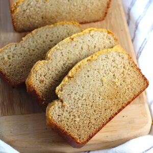 Cassava Bread loaf on a wood cutting board with 3 slices cut and fanned out.