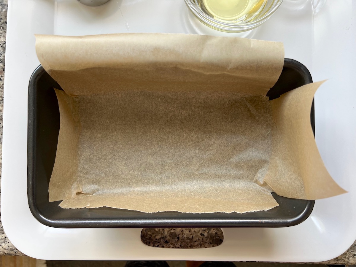 Loaf pan lined with parchment paper for the Cassava Bread recipe.