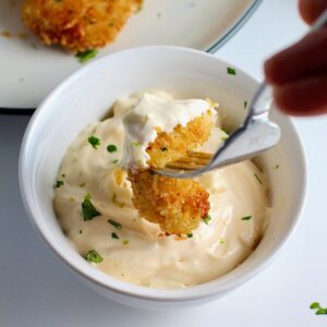 Fork dipping piece of panko chicken into Lime aioli.