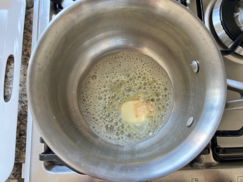 Butter and garlic cooking in a saucepan for Spicy Sausage Pasta.
