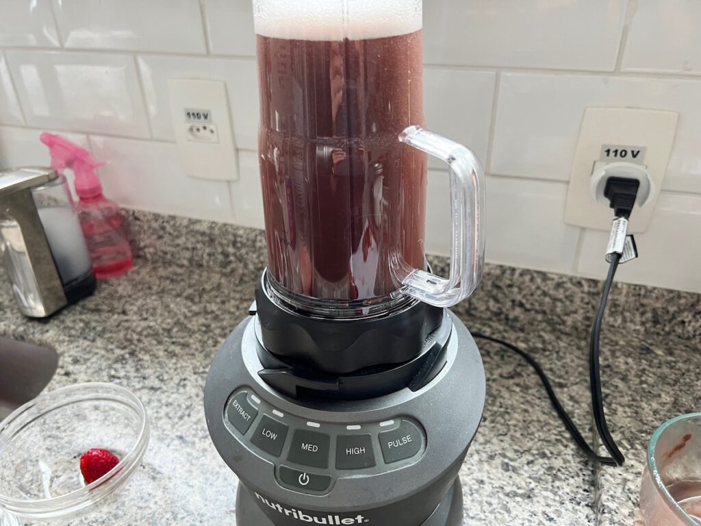 Acai and sugar simple syrup blending in a smoothie blender for How to make Strawberry Acai Refresher.