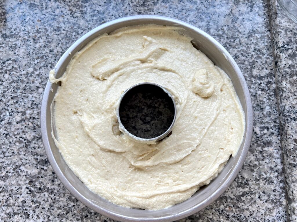 Batter in a tube pan for Orange Bundt Cake recipe.