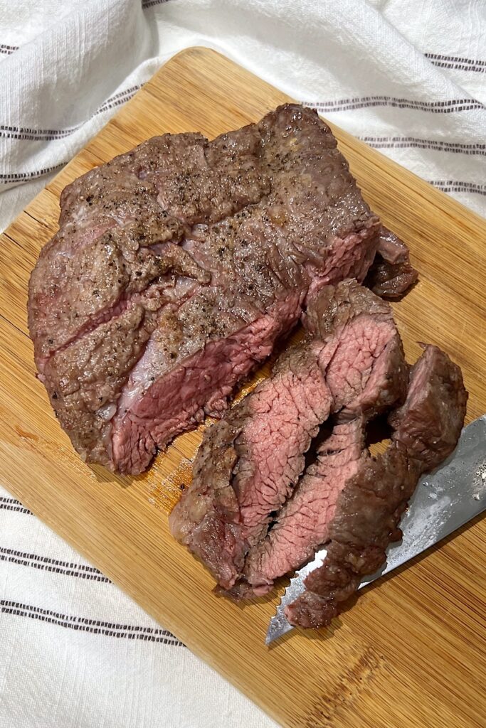 Flank Steak being sliced on cutting board to show Churrasco in the air fryer.