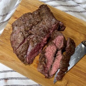 Flank Steak being sliced on cutting board to show Churrasco in the air fryer.