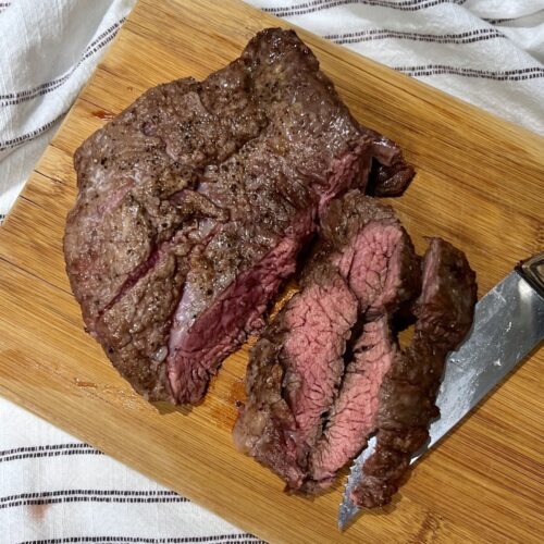 Flank Steak being sliced on cutting board to show Churrasco in the air fryer.