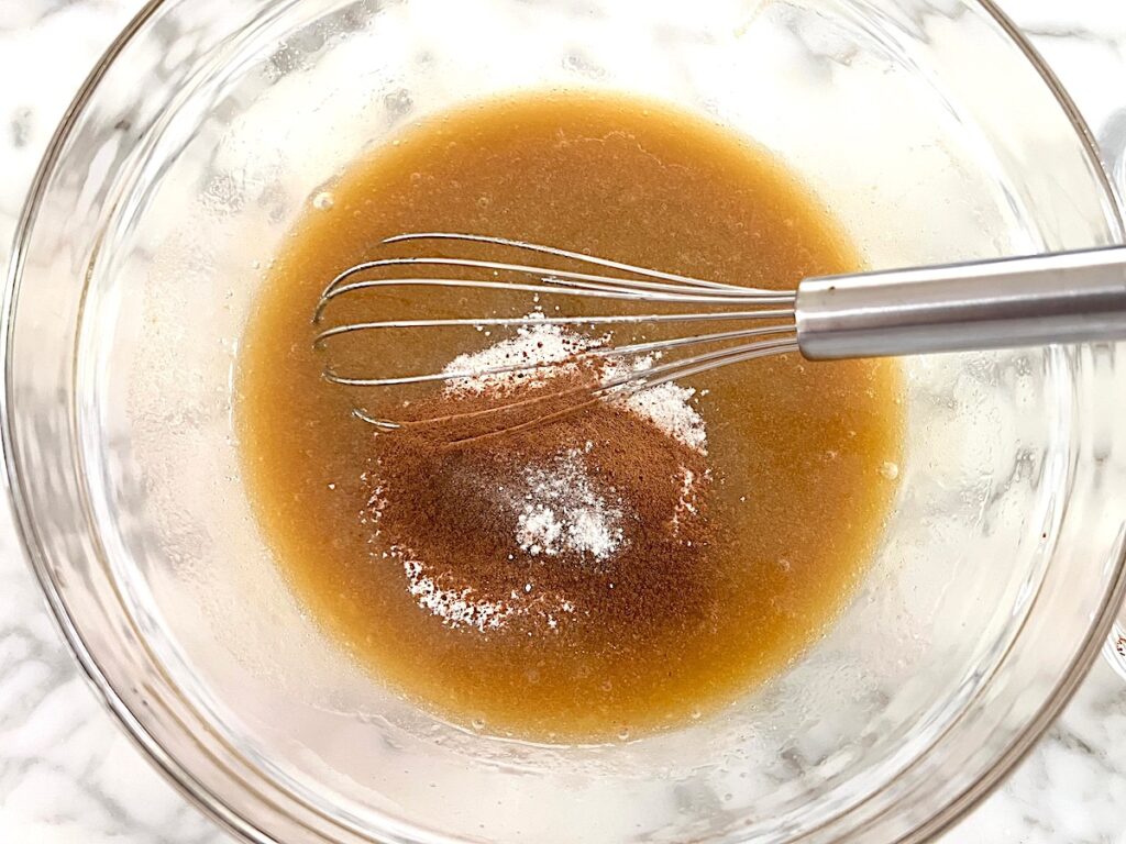 Spices added to batter in clear glass bowl for the Honey Loaf recipe.