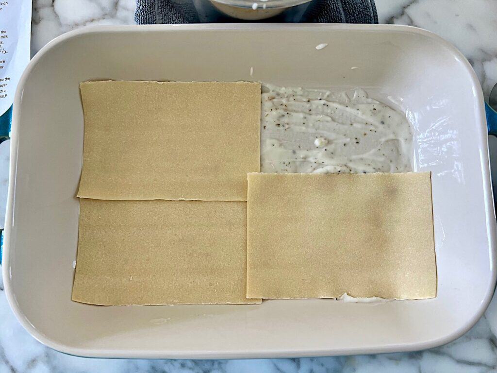 Bechamel Sauce and 3 of the 4 Lasagna sheets laid down in the casserole dish.