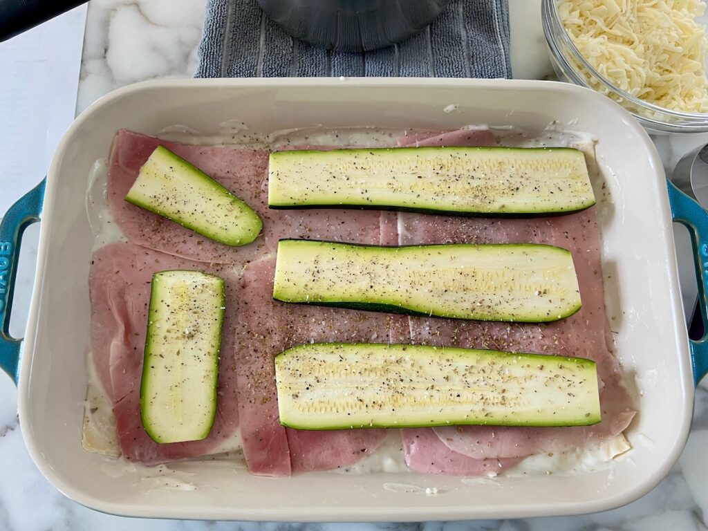 Final layers of ham, zucchini, and seasoning on the Bechamel Sauce Lasagna recipe.